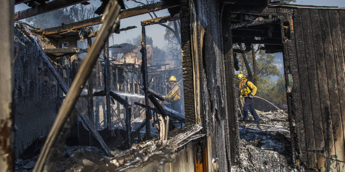 Los bomberos luchan contra el Getty Fire en casas en llamas en Brentwood, California, el 28 de octubre de 2019.